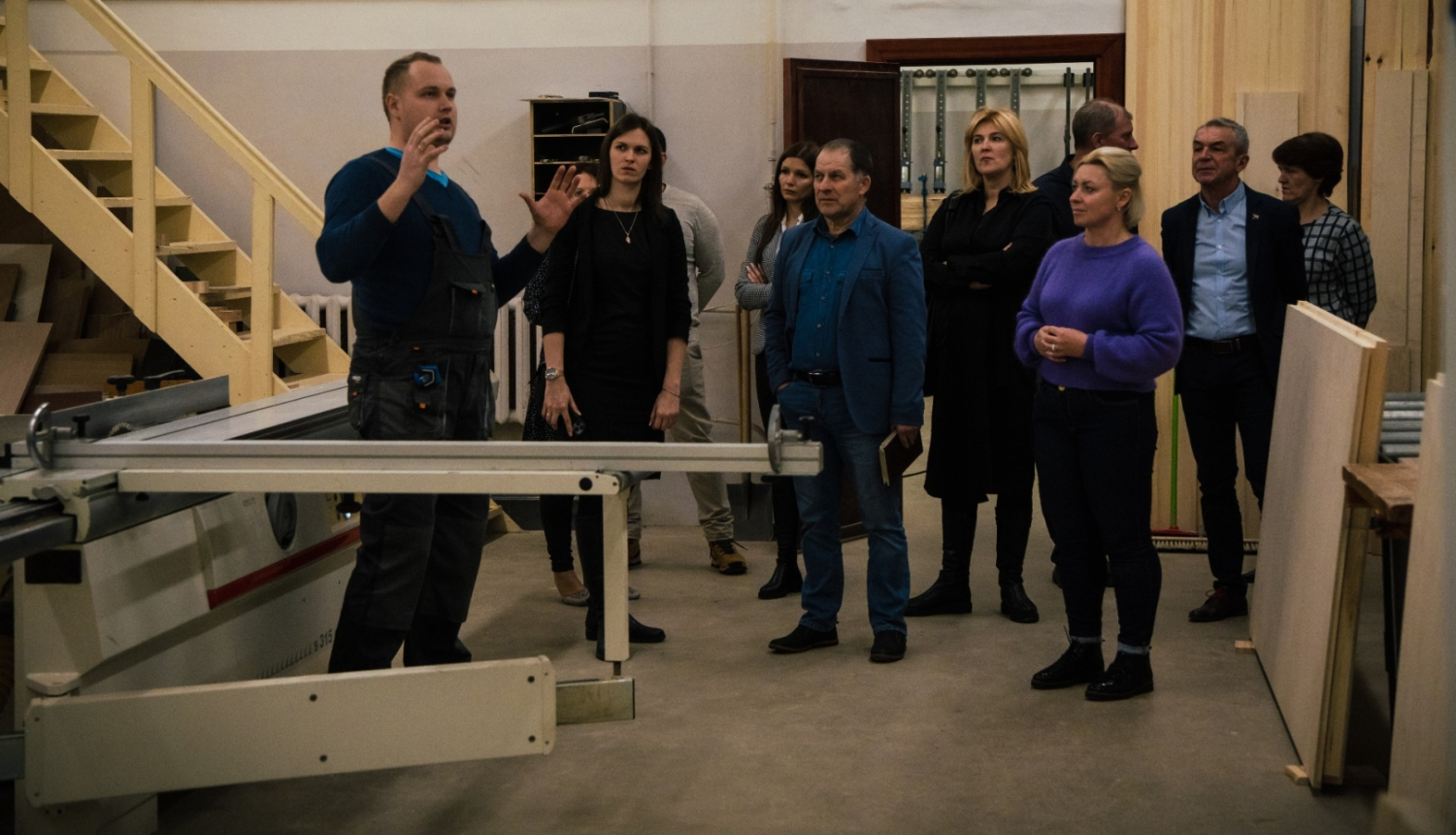 skolotājs stāsta uzņēmejiem par mācībām