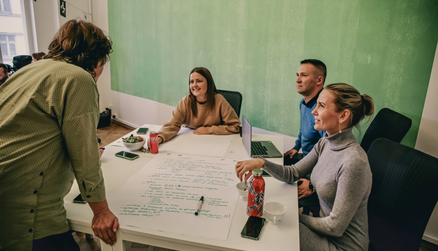 cilvēki sēž sapulcē 