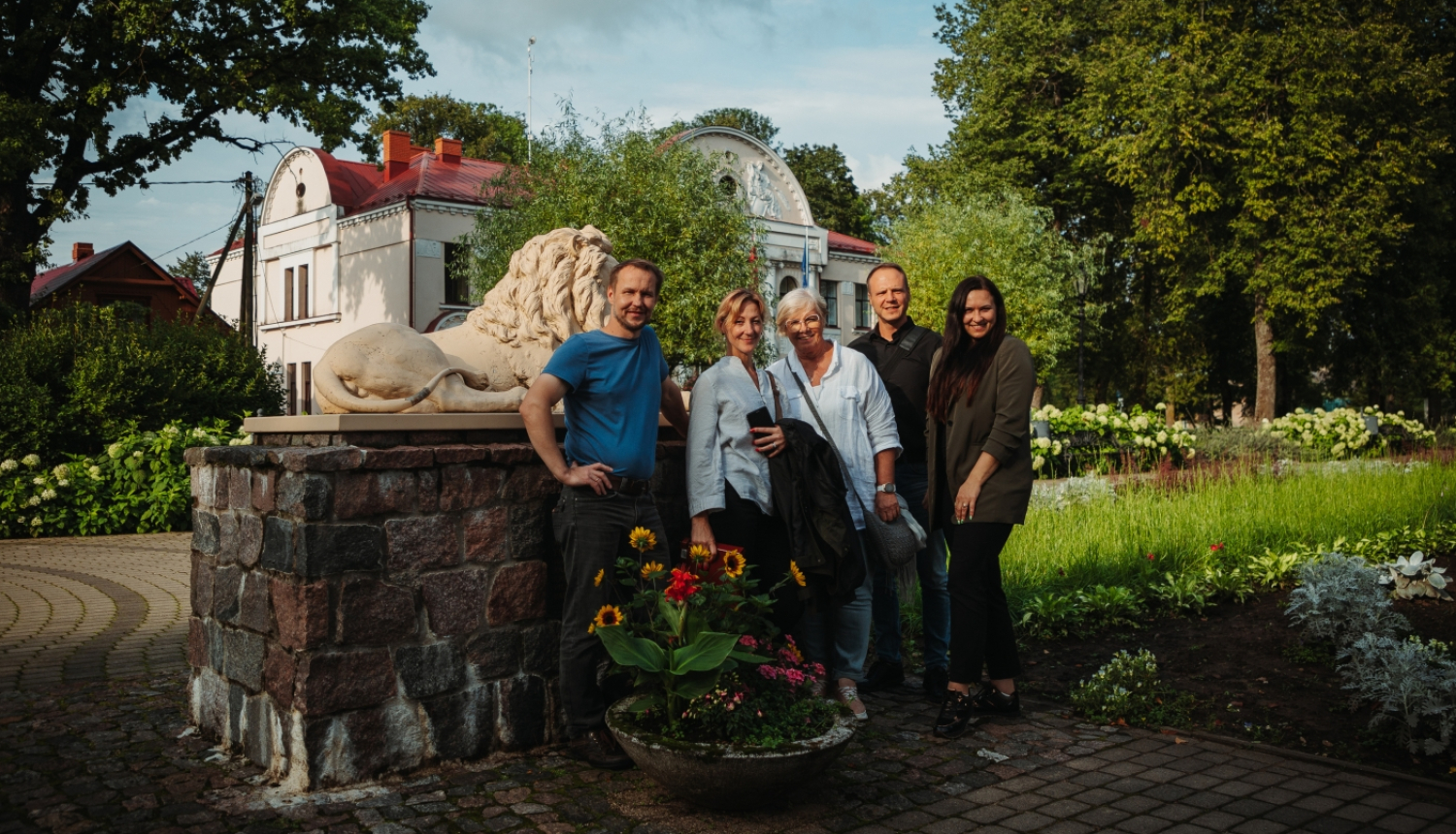 Cilvēku kopbilde pie lauvas pieminekļa