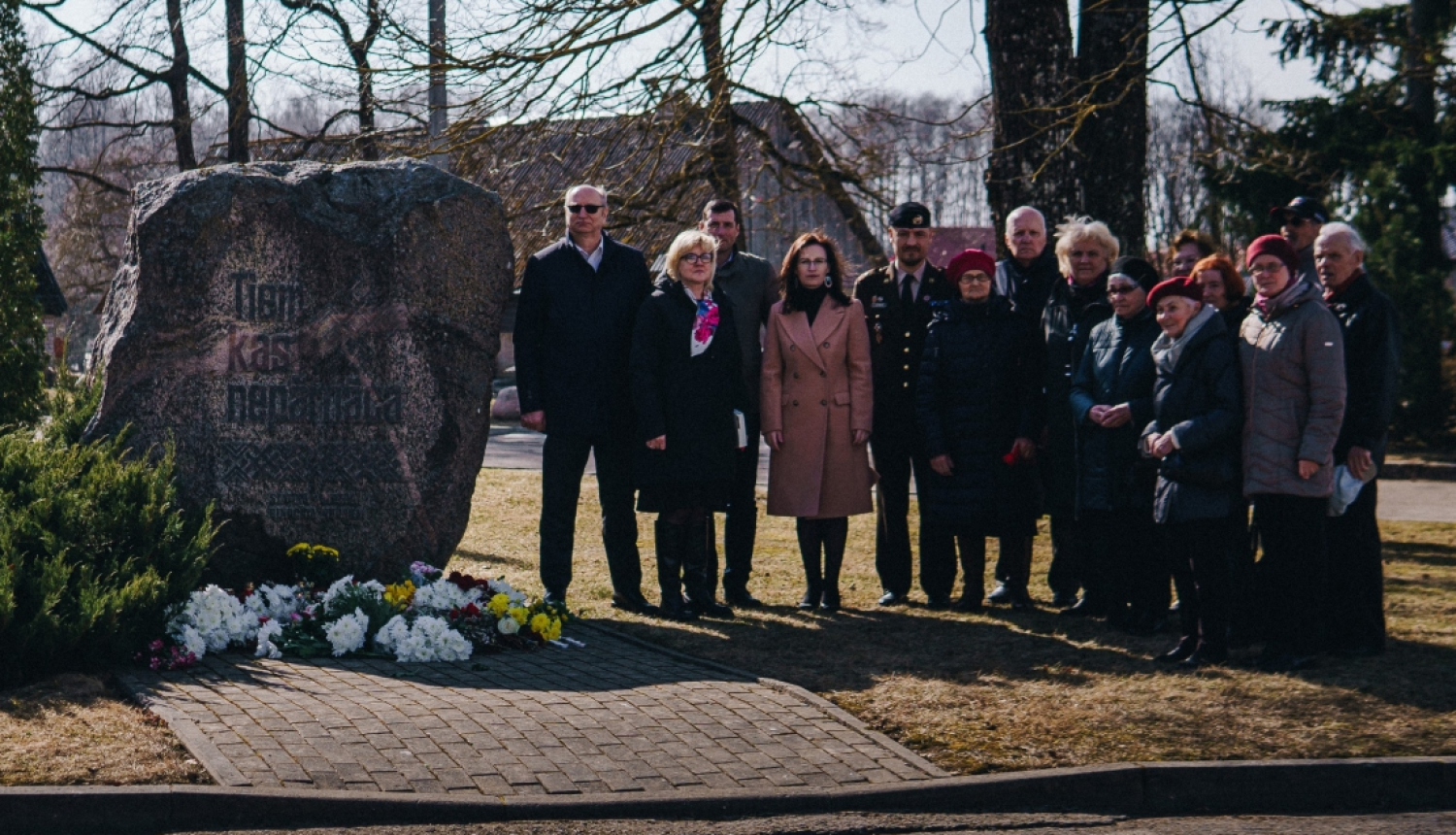 cilēki pulcējas pie piemiņas akmens atceres dienā