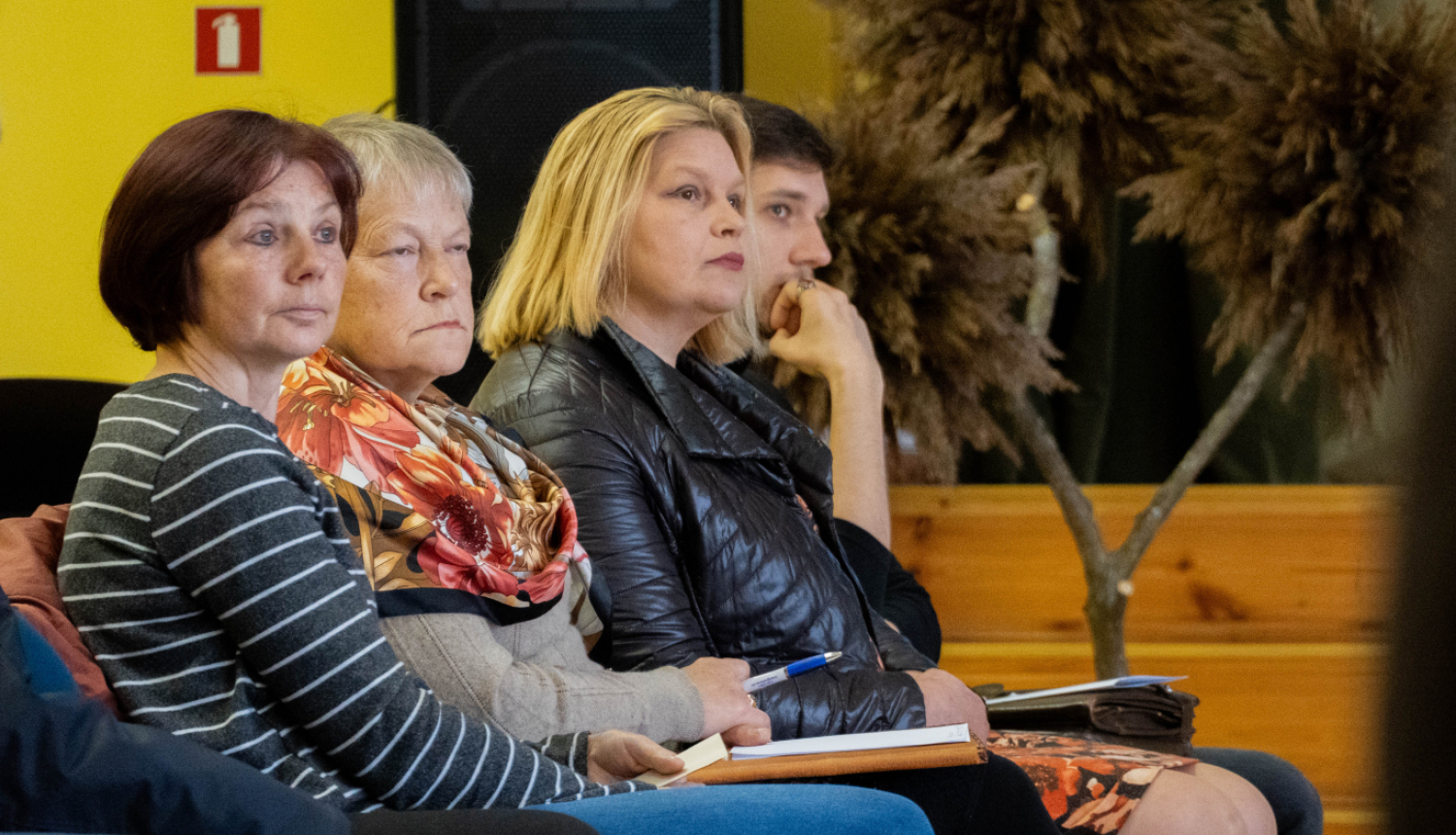 Cilvēki klausās prezentāciju