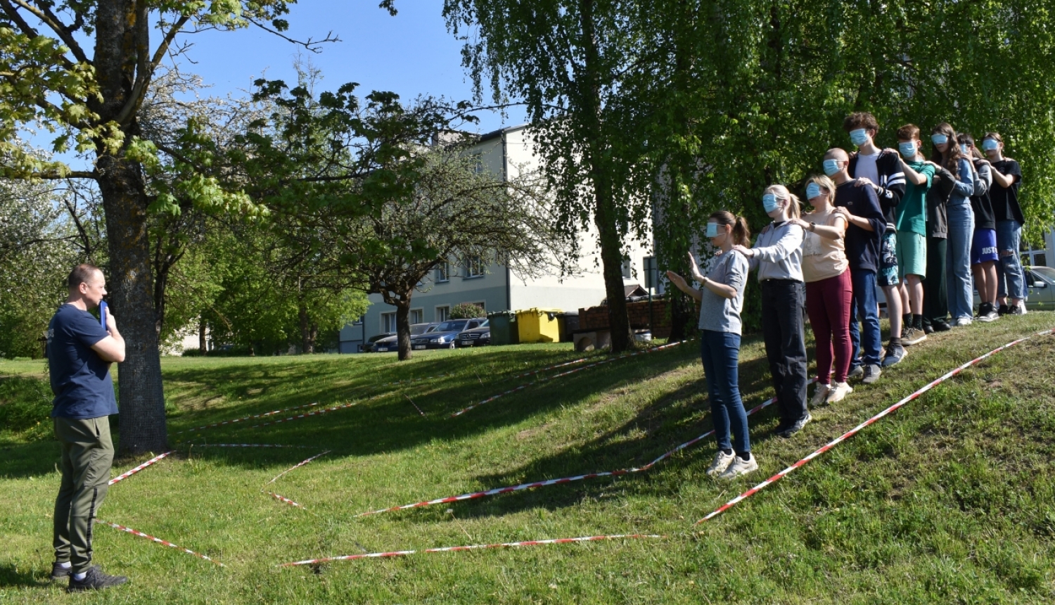 aizsietām acīm jaunieši iet lejā no kalna